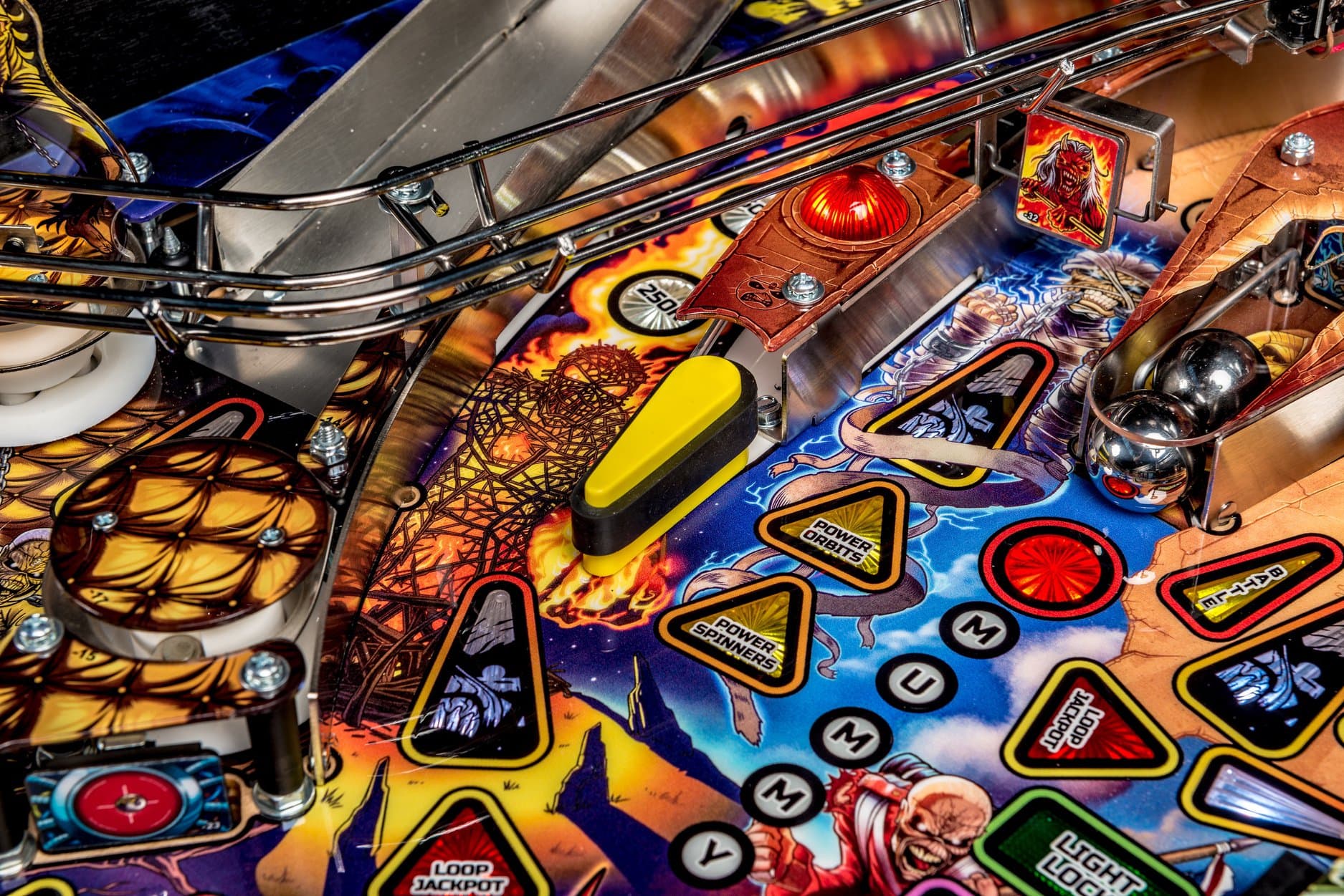 Colorful pinball machine playfield with metal tracks and vibrant graphics