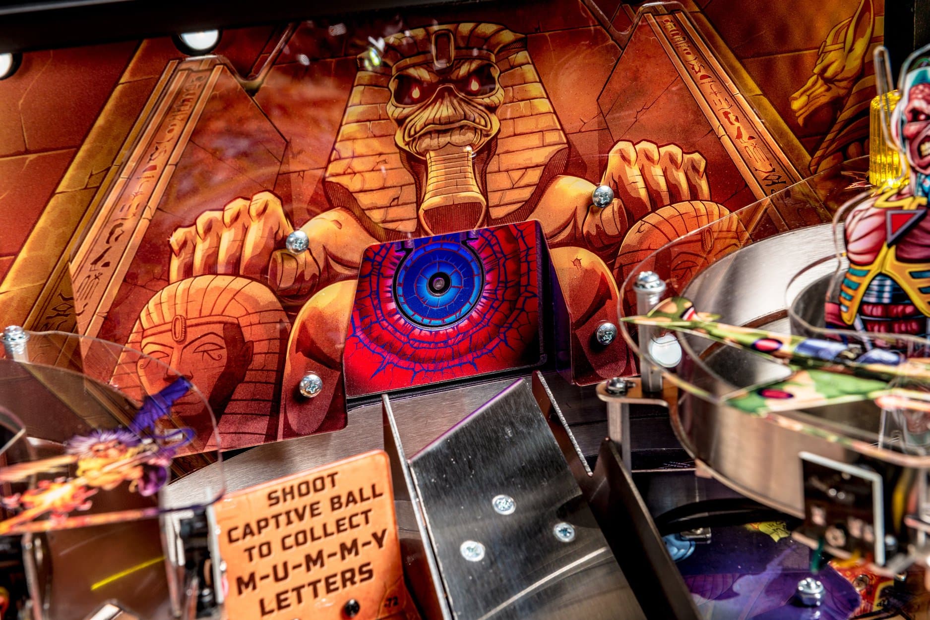 Egyptian-themed pinball machine with pharaoh statues and colorful eye design