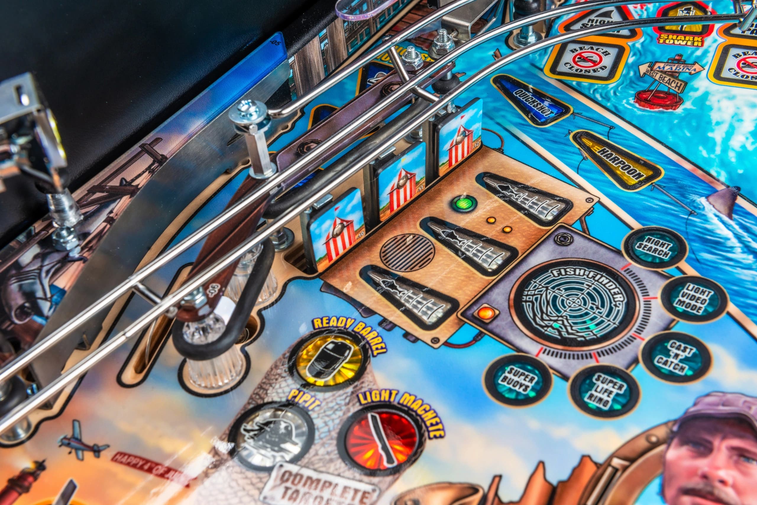 Colorful pinball machine playfield with metallic rails and themed buttons