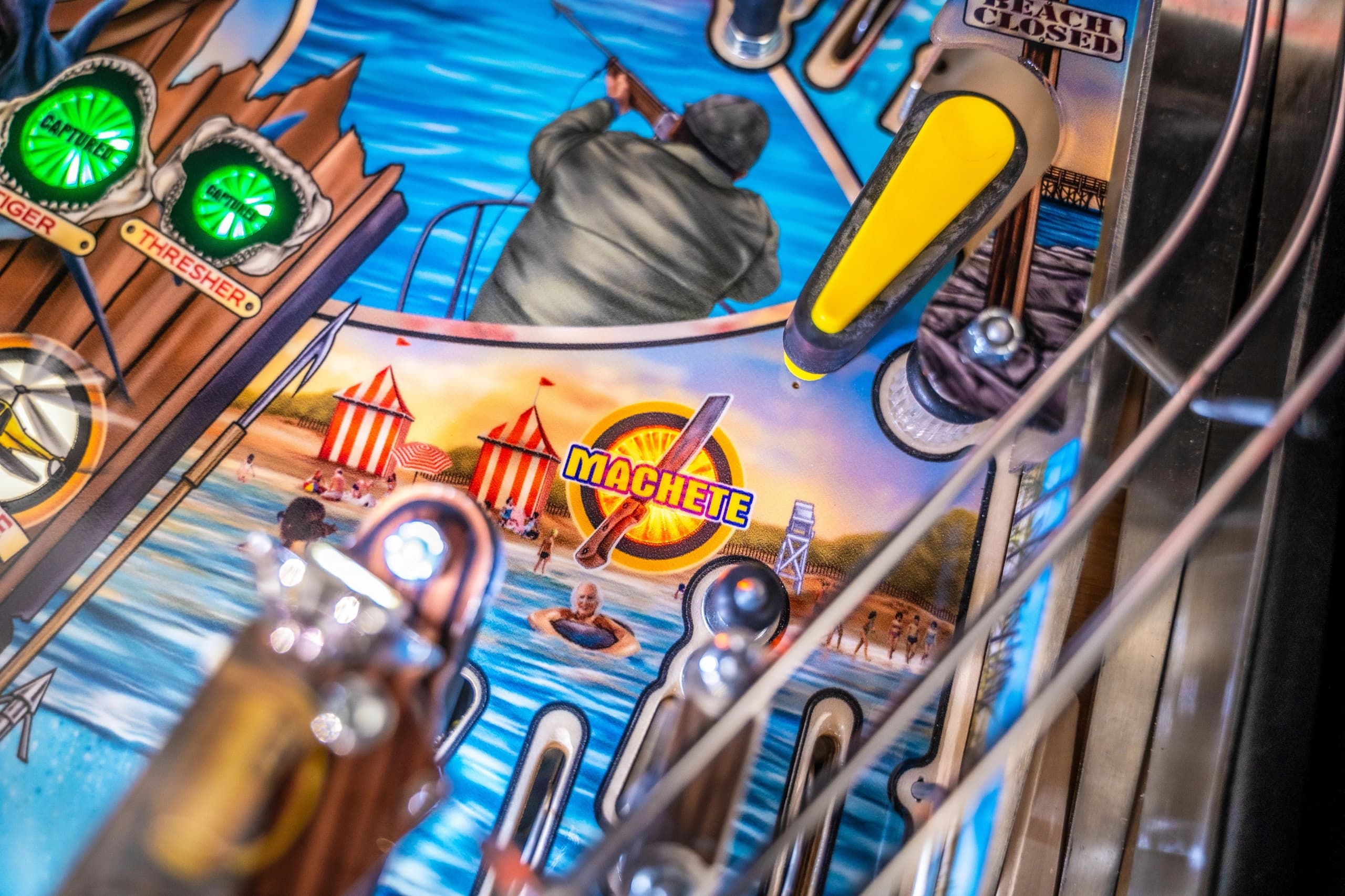 Detailed close-up of a colorful pinball machine with beach and summer theme