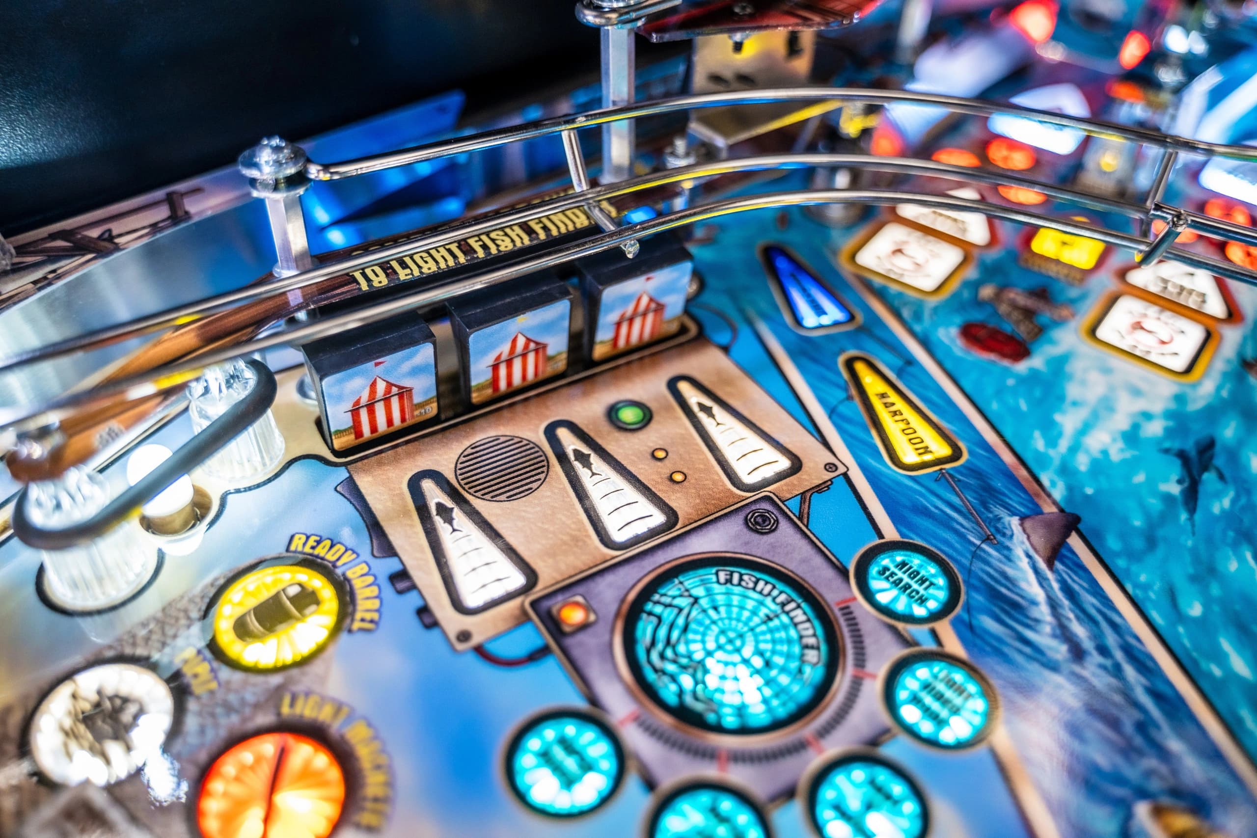 Detailed pinball machine playfield with colorful lights and electronic components