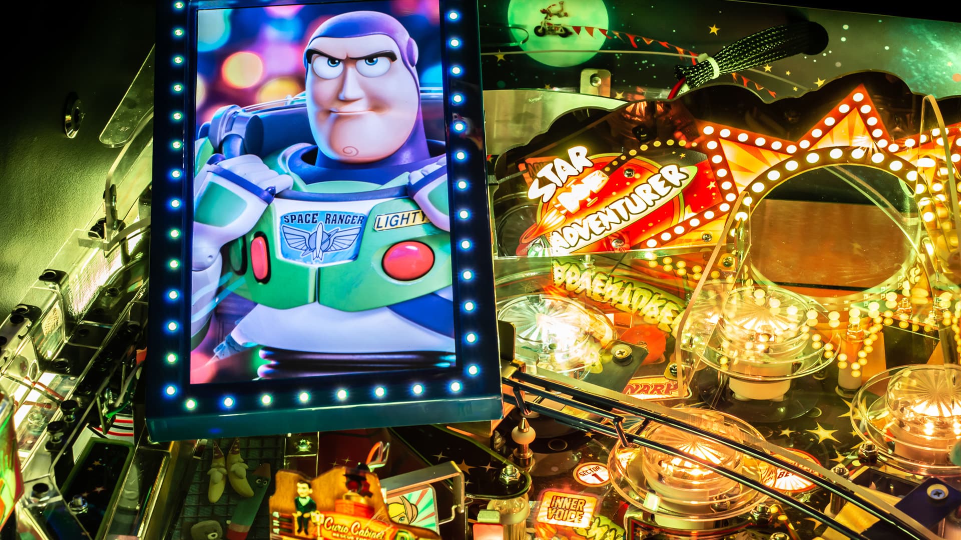 Buzz Lightyear on pinball machine screen with colorful space adventure backdrop