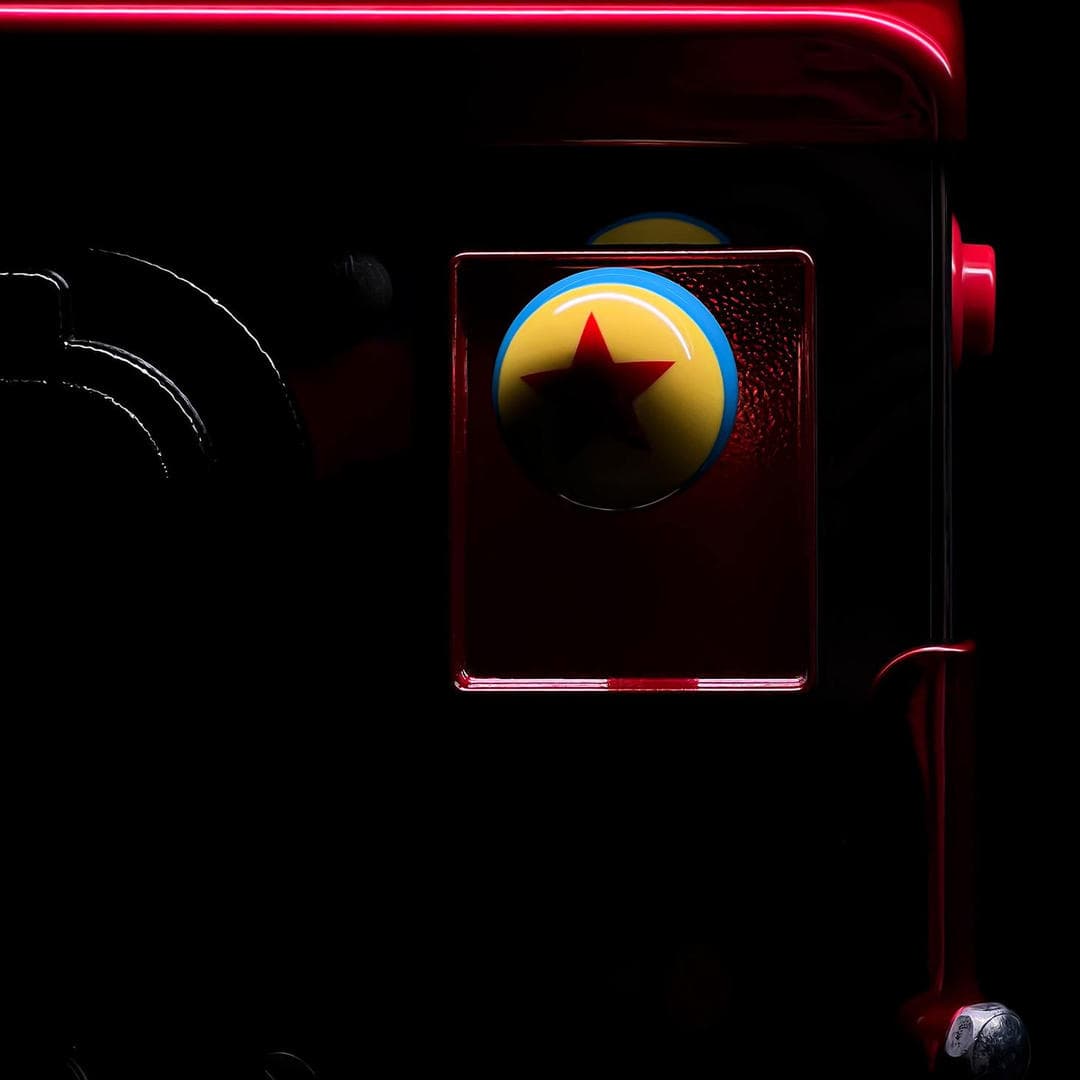 Pixar ball with red star on yellow and blue background inside dark frame