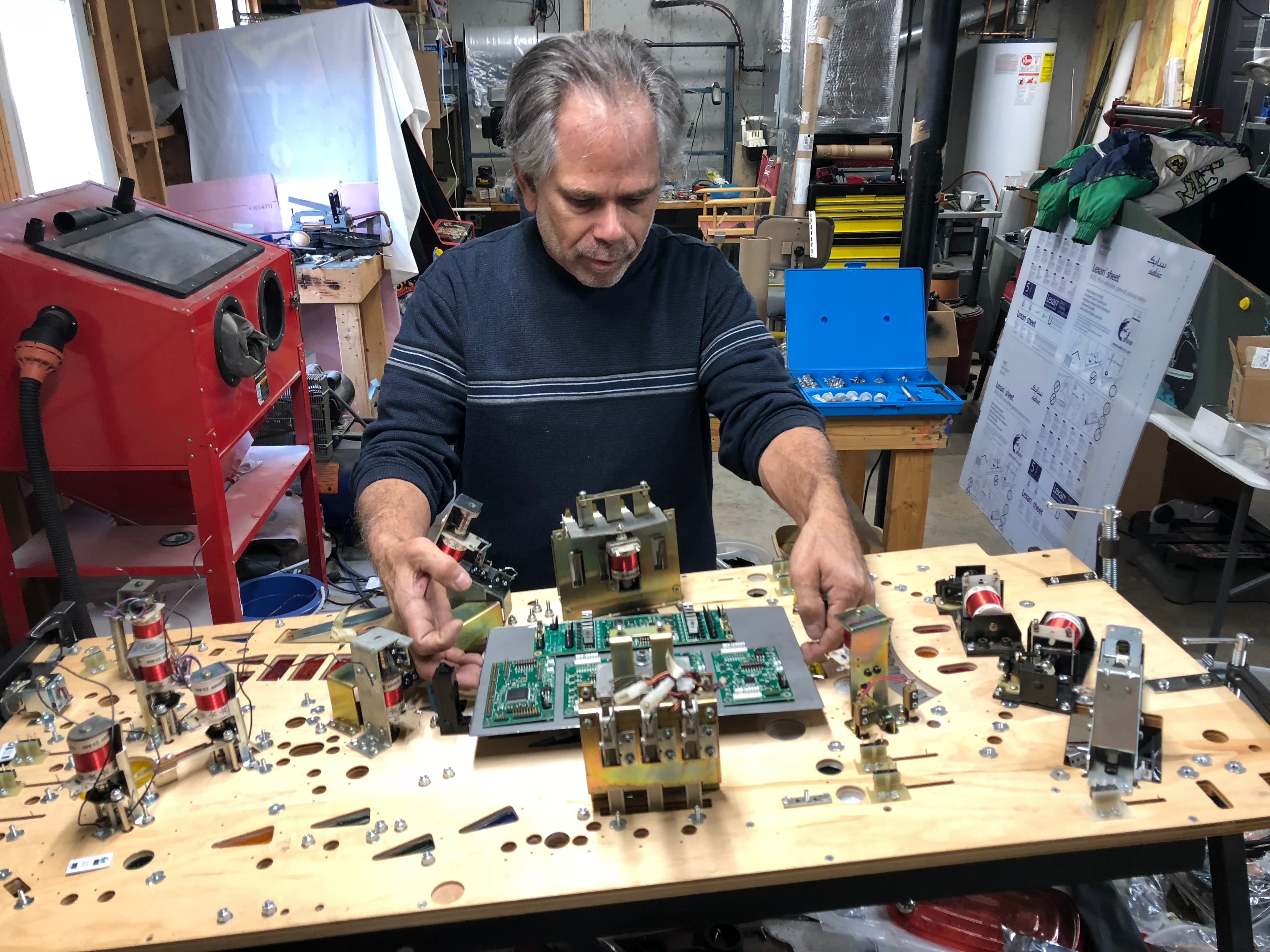 Technician working on complex electronic components in a workshop