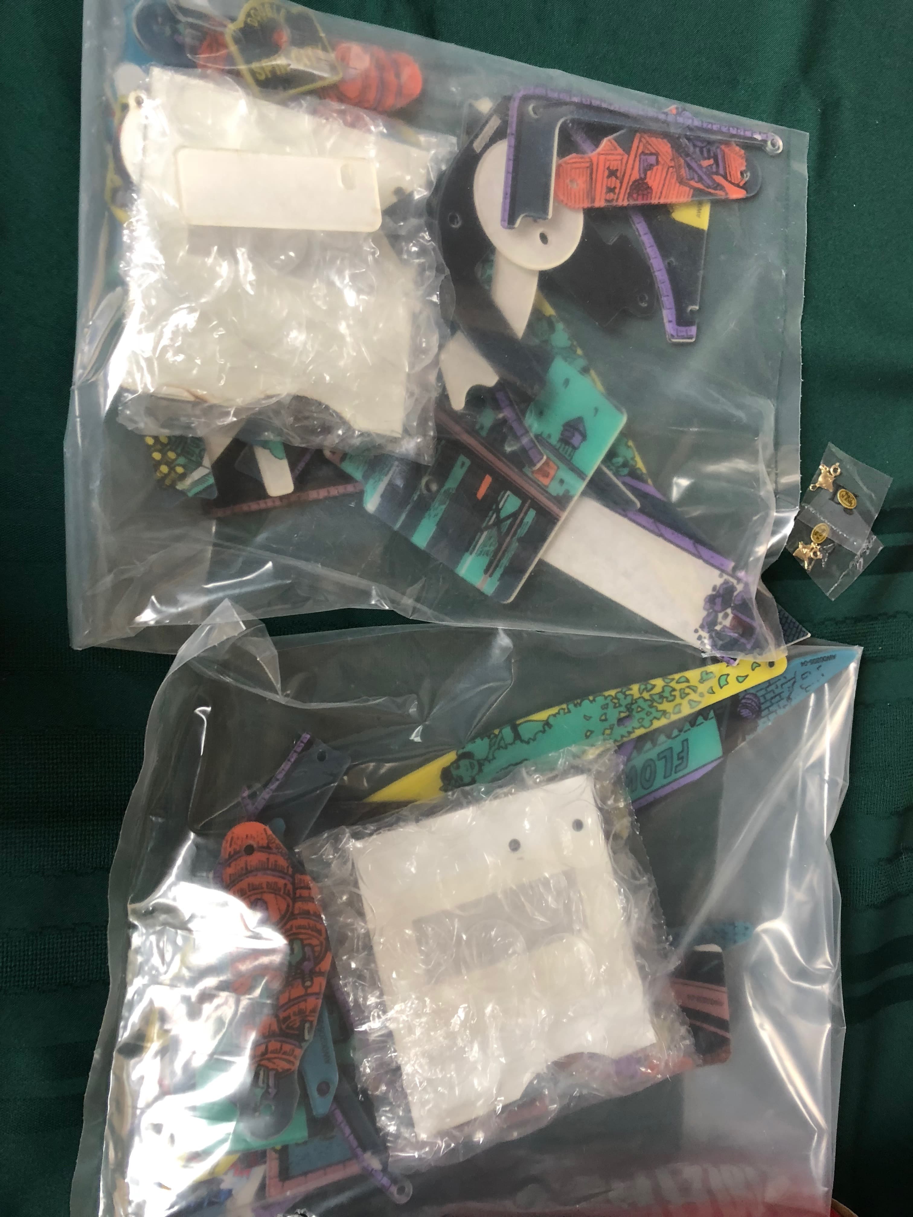 Plastic bag with colorful enamel pins and white packaging materials