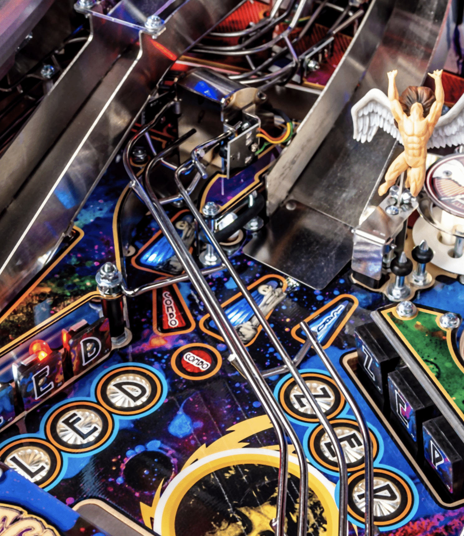 Colorful pinball machine interior with mechanical components and angel figurine