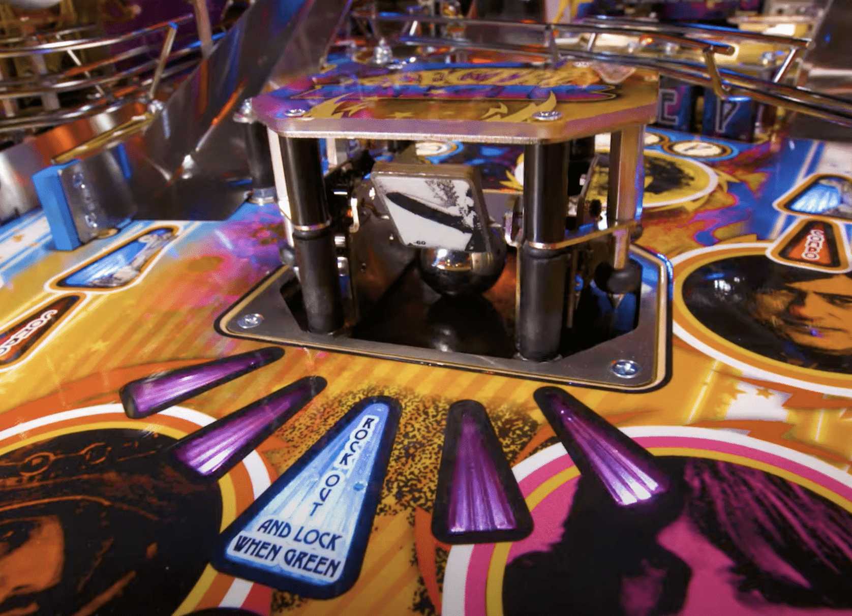 Colorful pinball machine with purple flippers and mechanical center mechanism