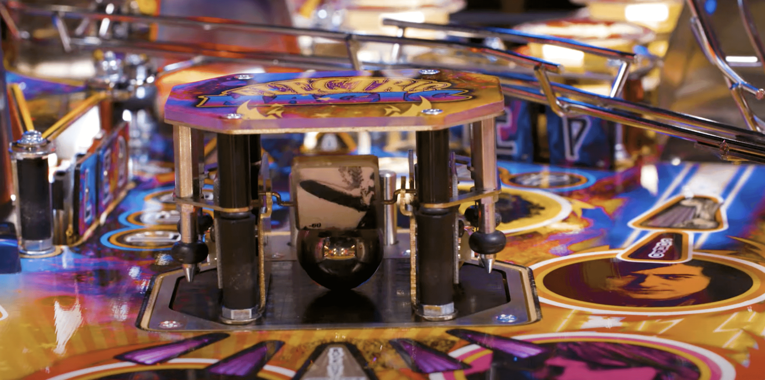 Colorful pinball machine with mechanical components and vibrant playfield design