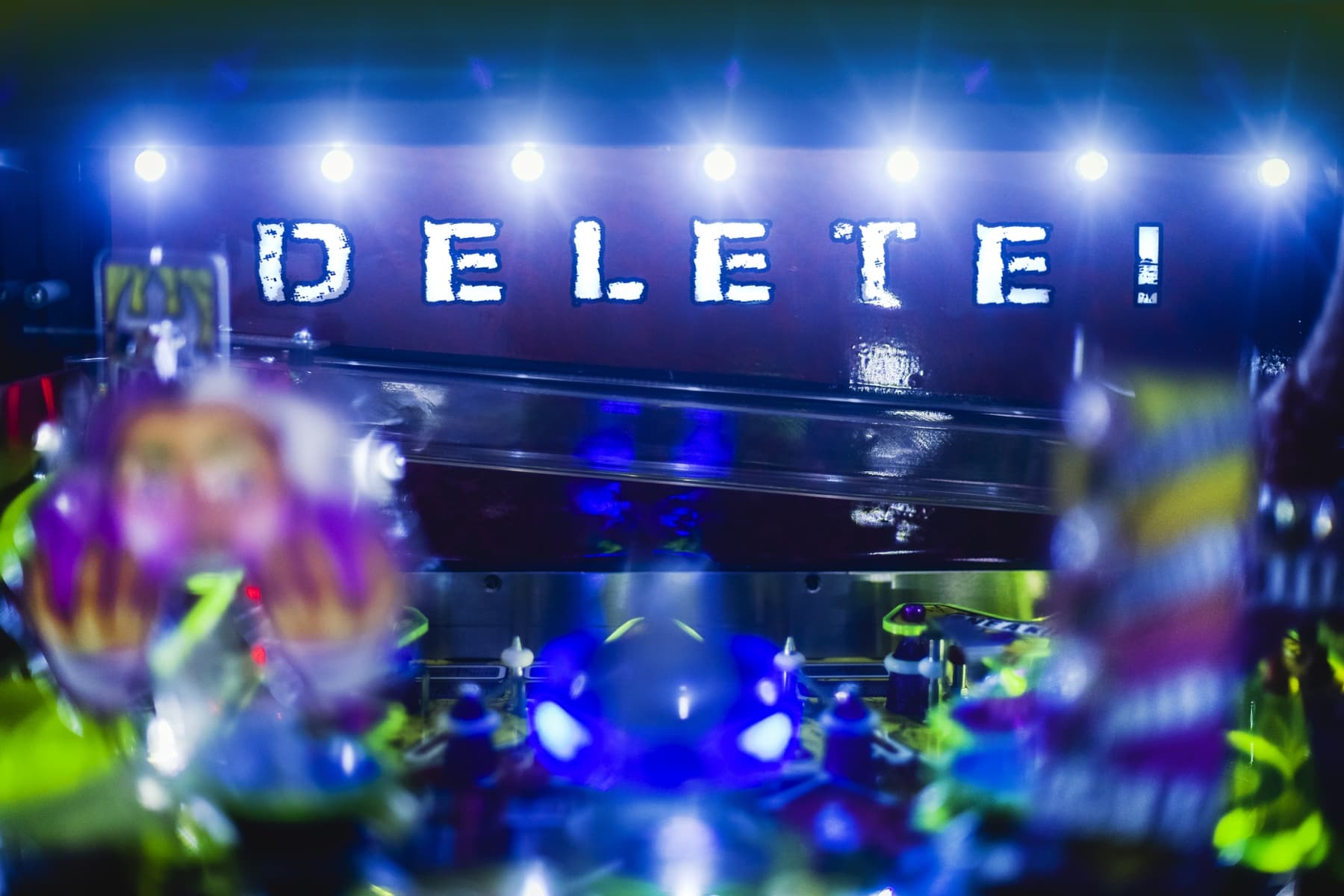 Delete text illuminated on dark background with blue and green lights