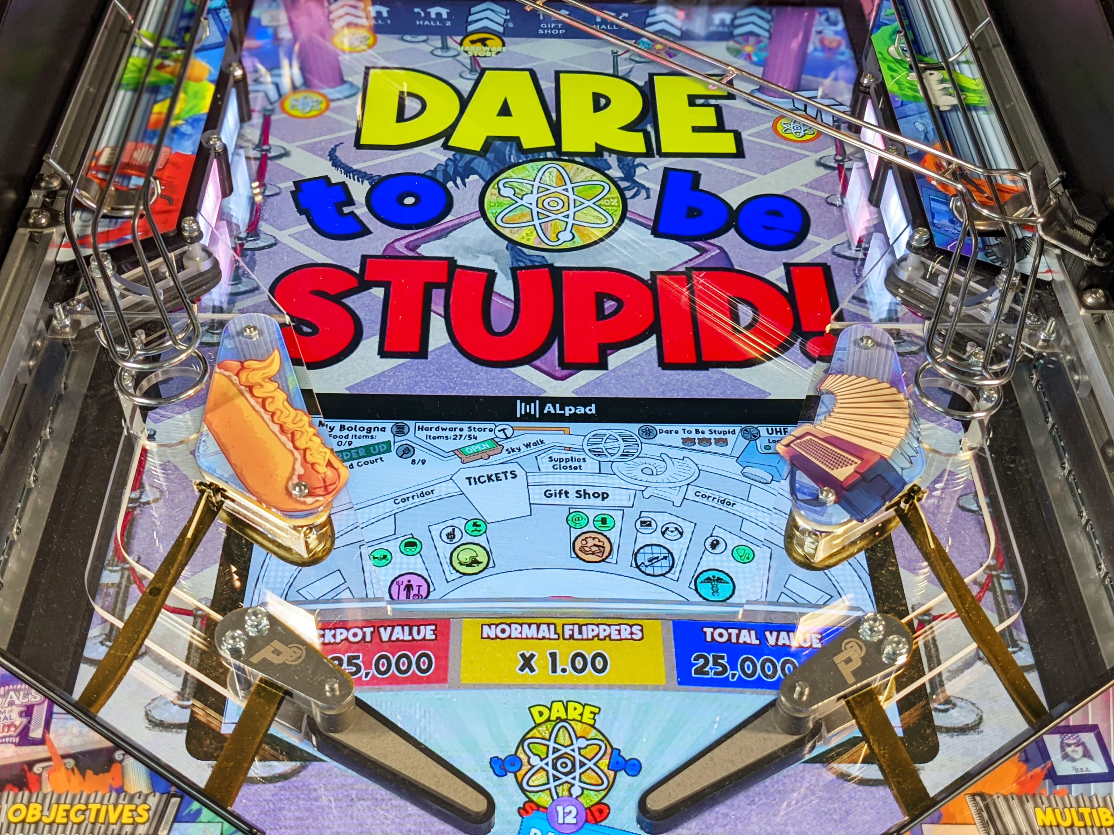Colorful pinball machine with "Dare to Be Stupid" title and playfield