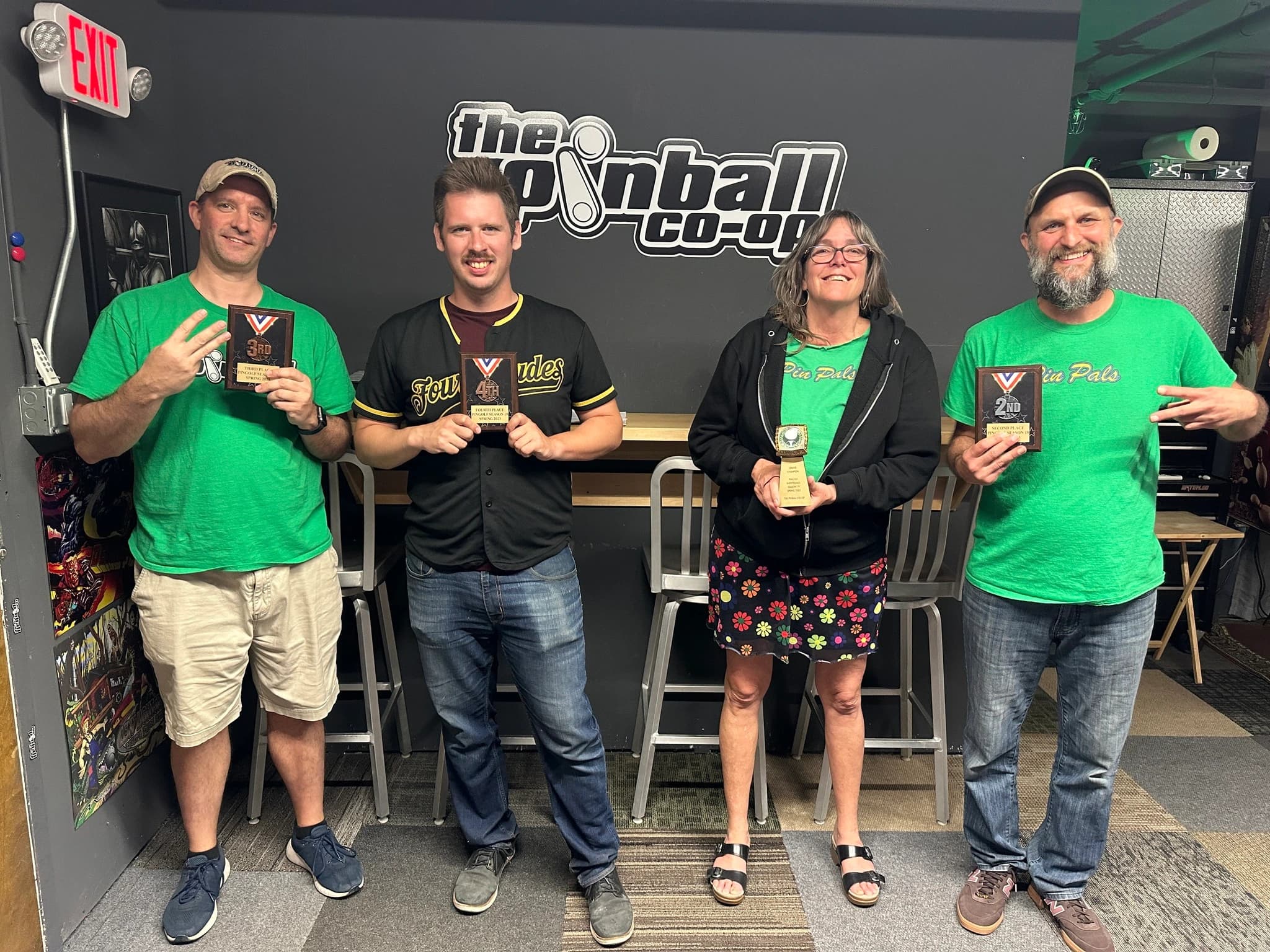 Four pinball players posing with awards at The Pinball Co-op