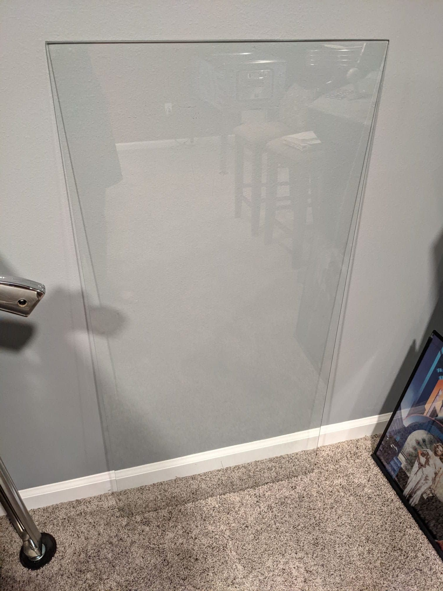 Frosted glass panel with blurry reflection, mounted on white wall with carpet