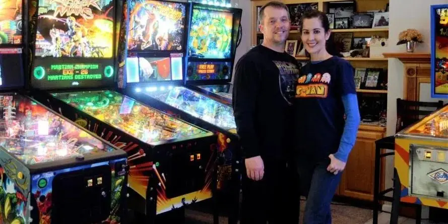 The husband and wife owners and some of their pinball collection