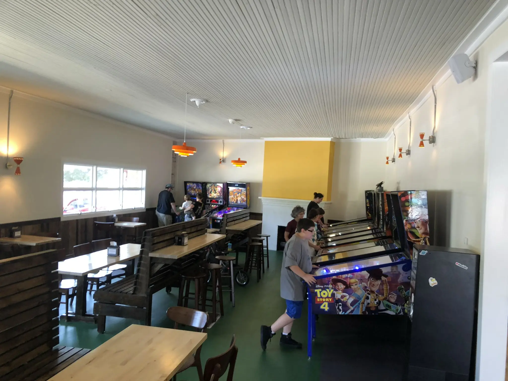 Pinball arcade with Toy Story 4 machine and people playing games