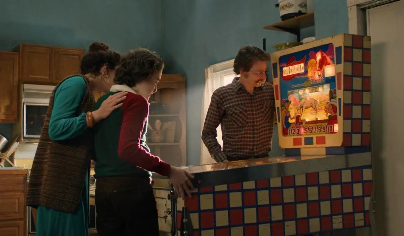 People in kitchen near colorful vintage light-up game board