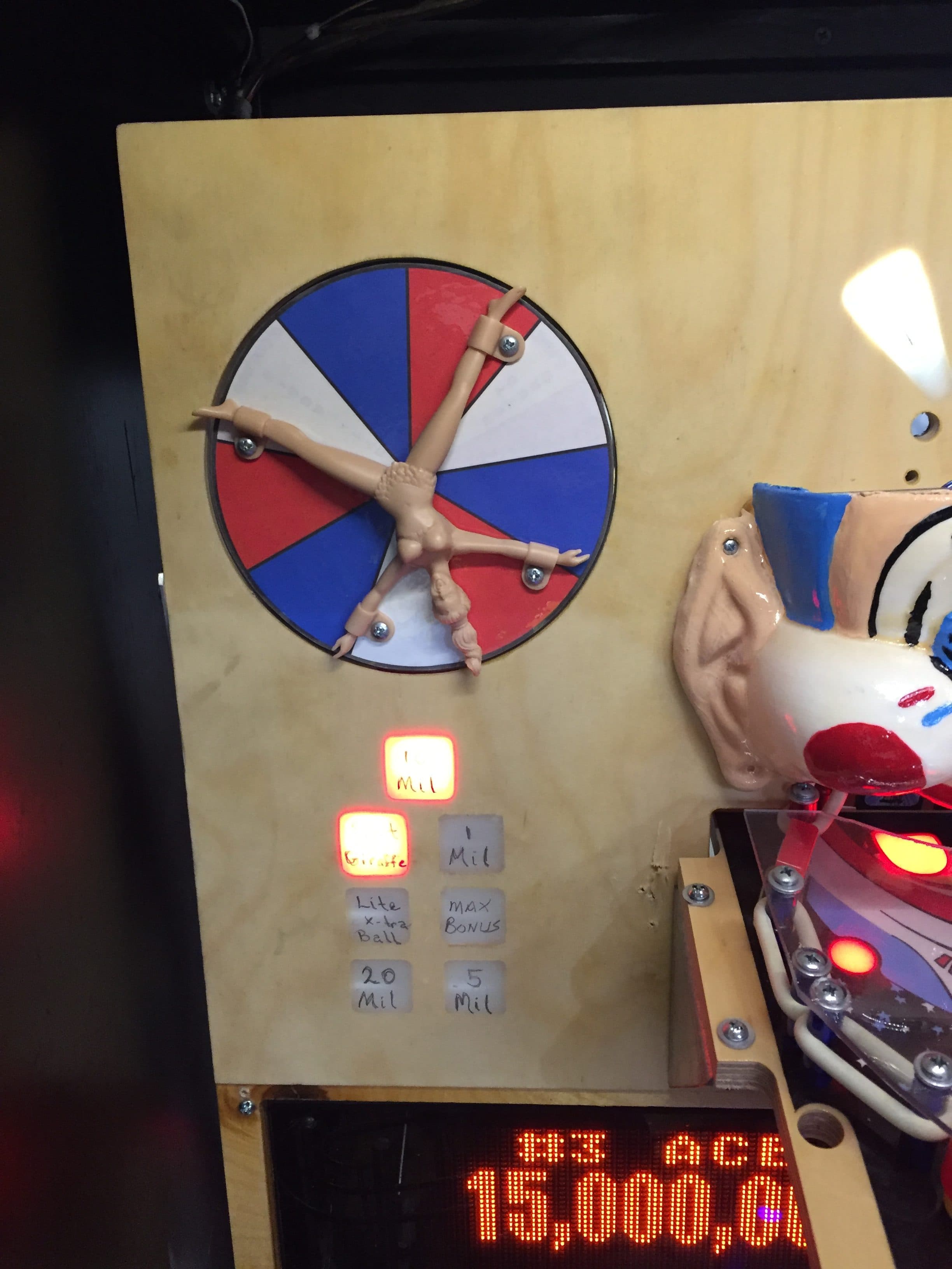 Colorful wheel with a doll-like figure at the center and game labels