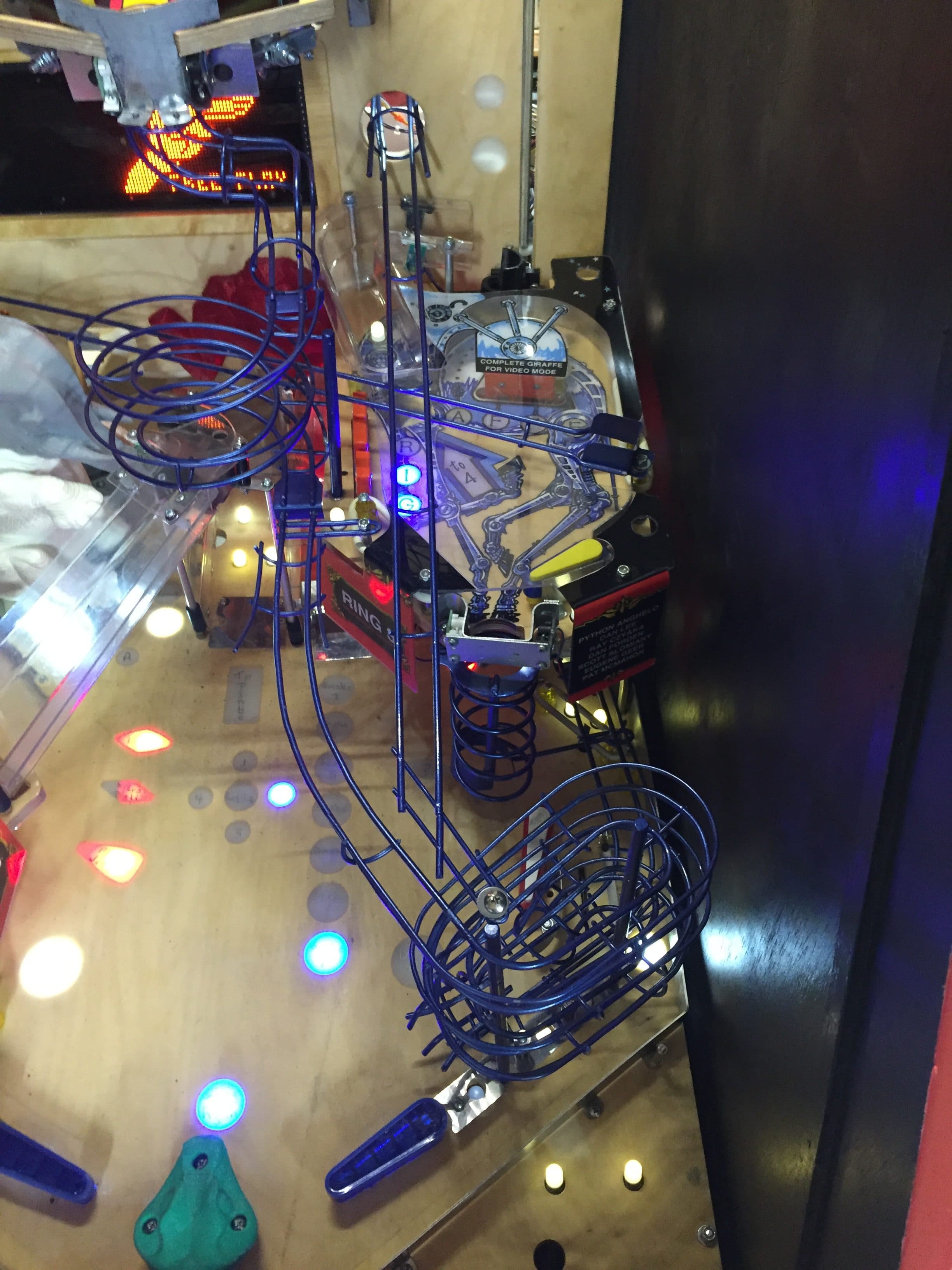 Pinball machine with blue metal tracks and colorful glowing lights