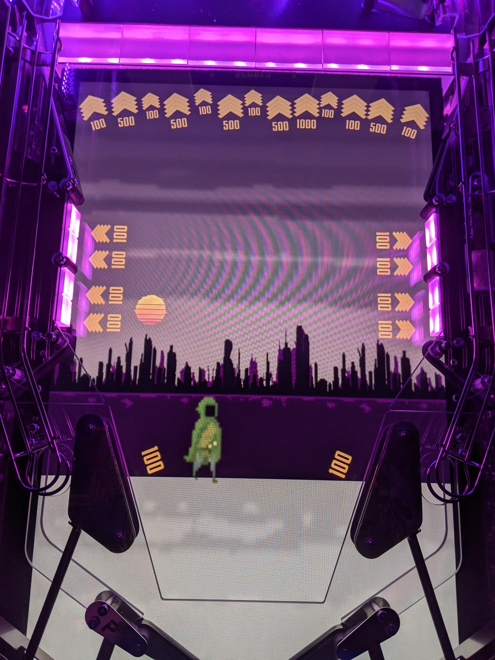 Retro arcade game screen with city skyline and pixelated green character