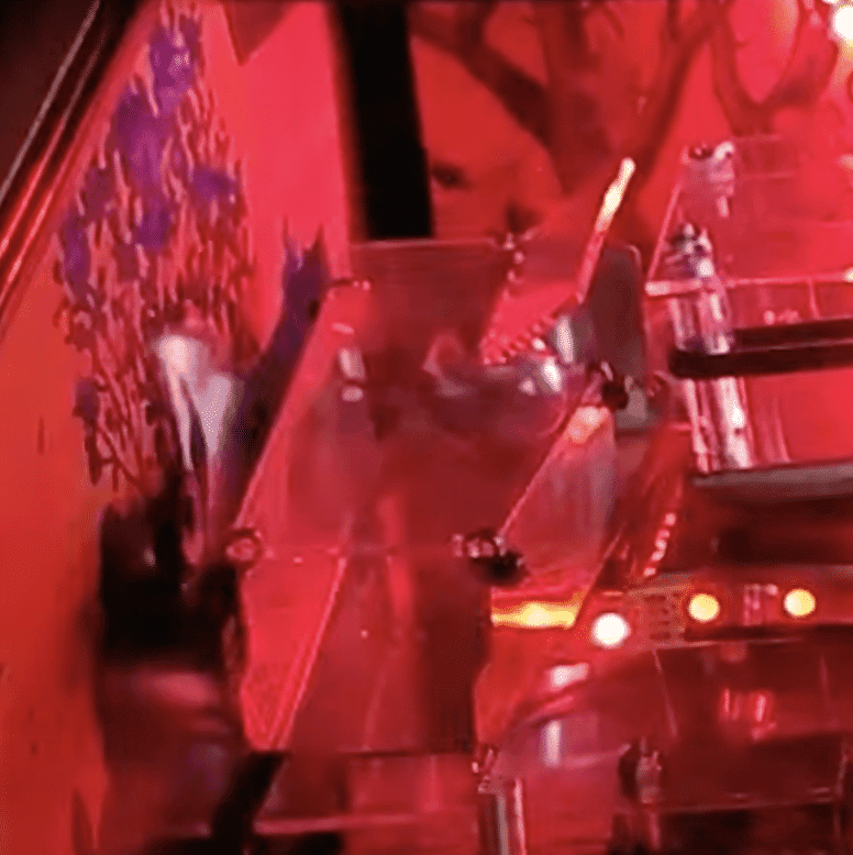 Blurry red-tinted scene with angular metallic shapes and glowing lights