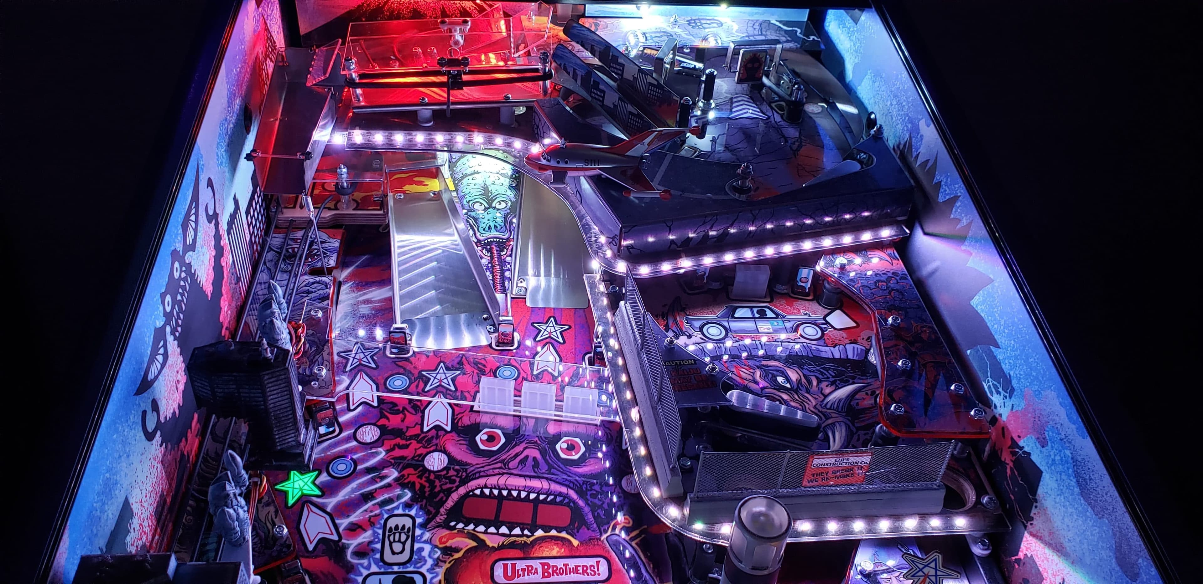 Colorful pinball machine with alien, stars, and Ultra Brothers theme