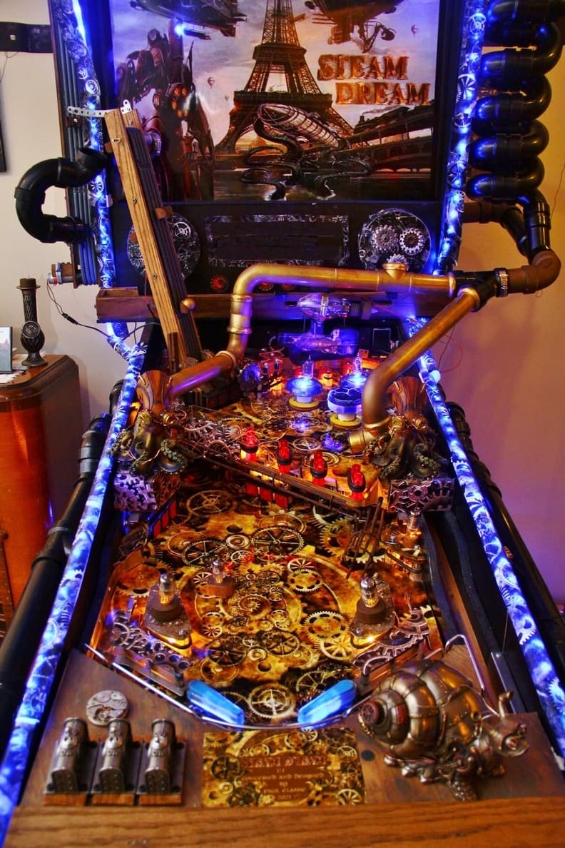 Steampunk-themed pinball machine with gears, pipes, and Eiffel Tower backdrop