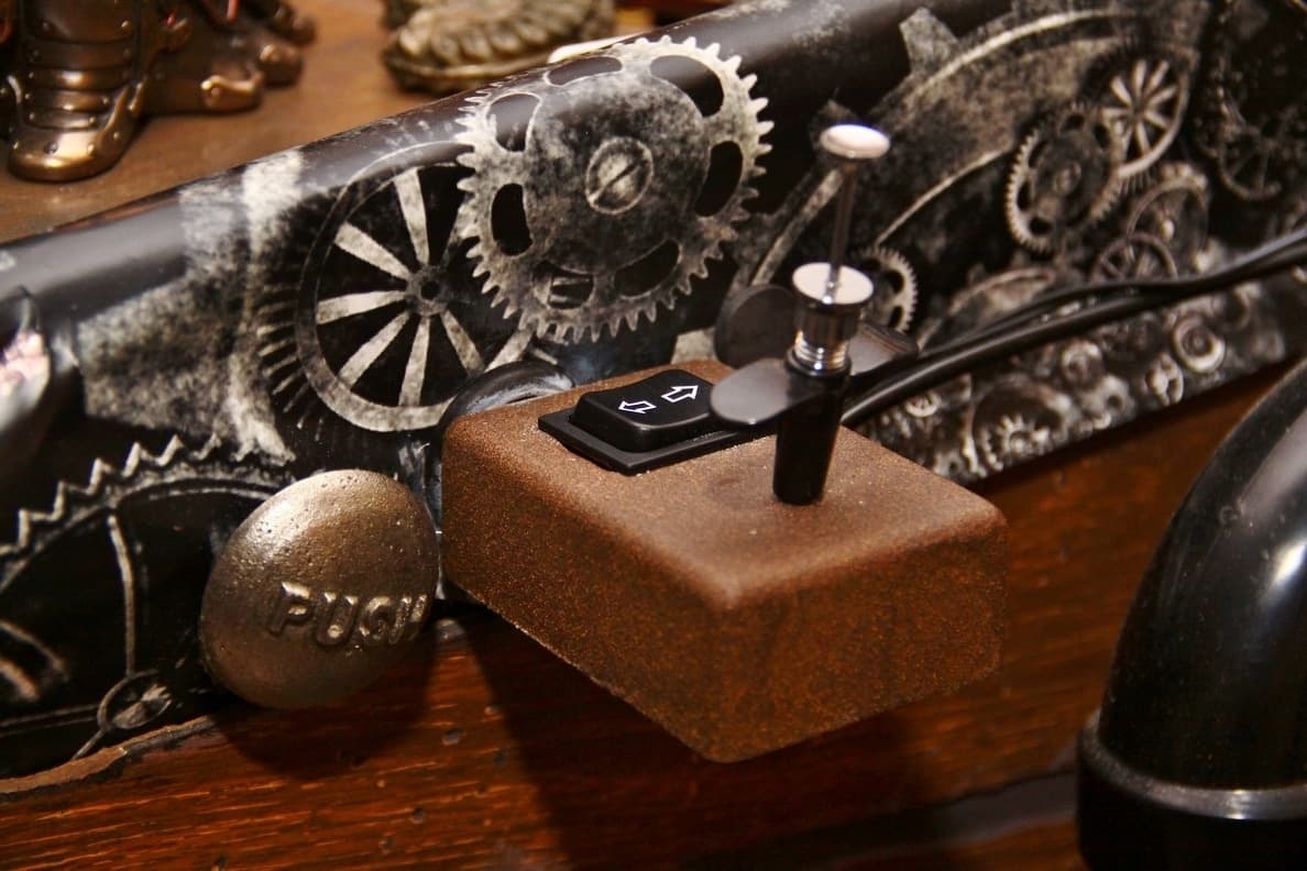 Vintage gears, metal ball, and control switch on wooden surface