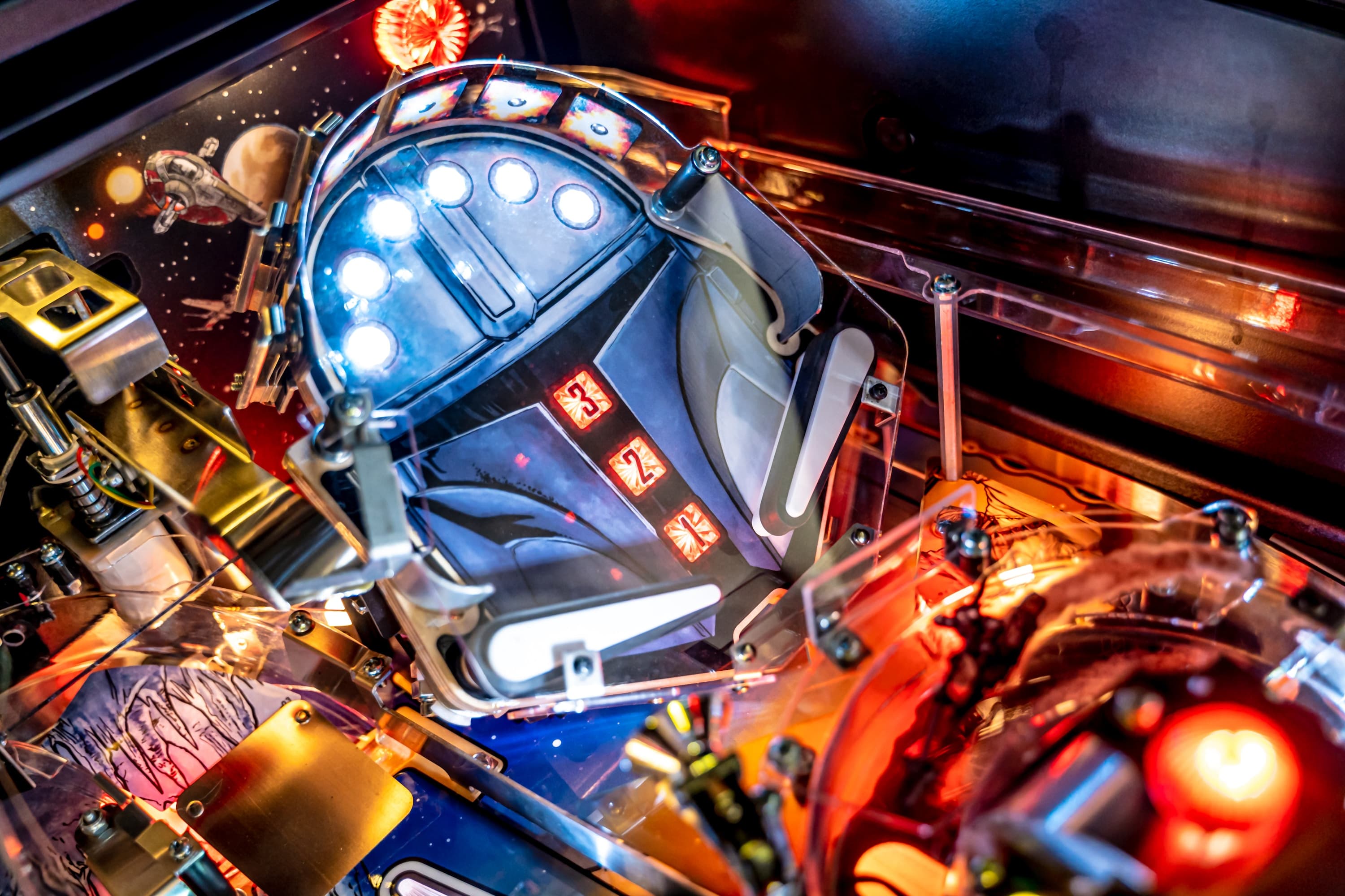 Detailed view of a colorful, illuminated pinball machine with sci-fi design