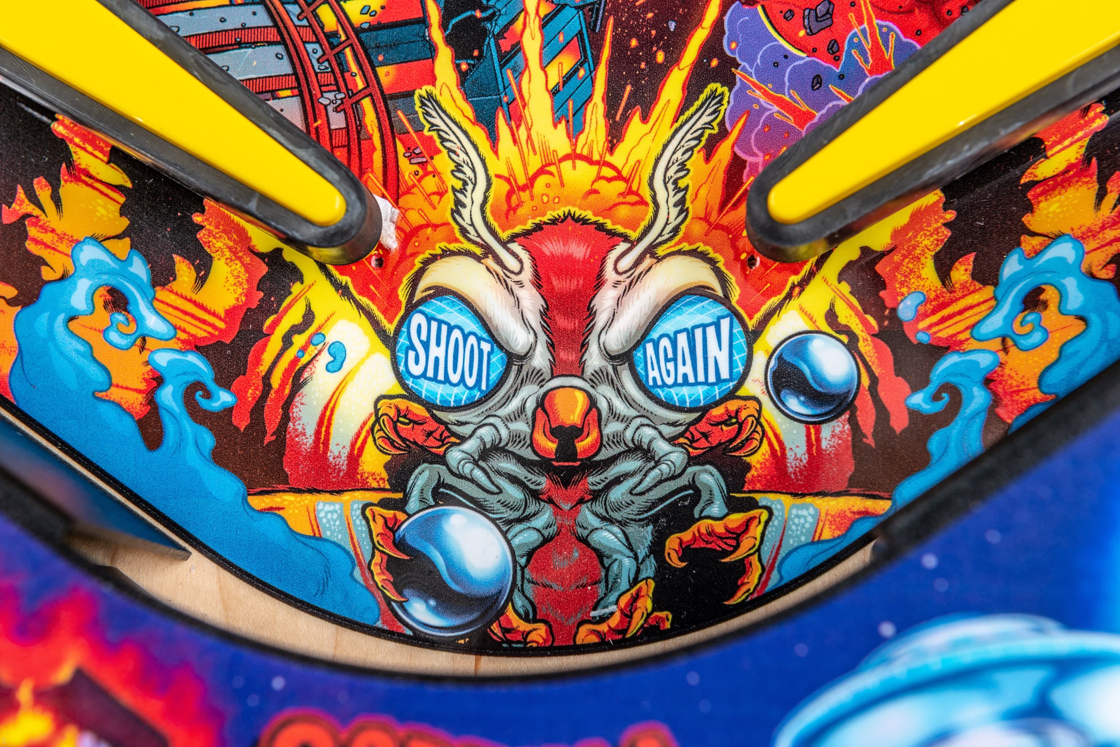 Colorful pinball machine art featuring intense rabbit with "Shoot Again" eyes