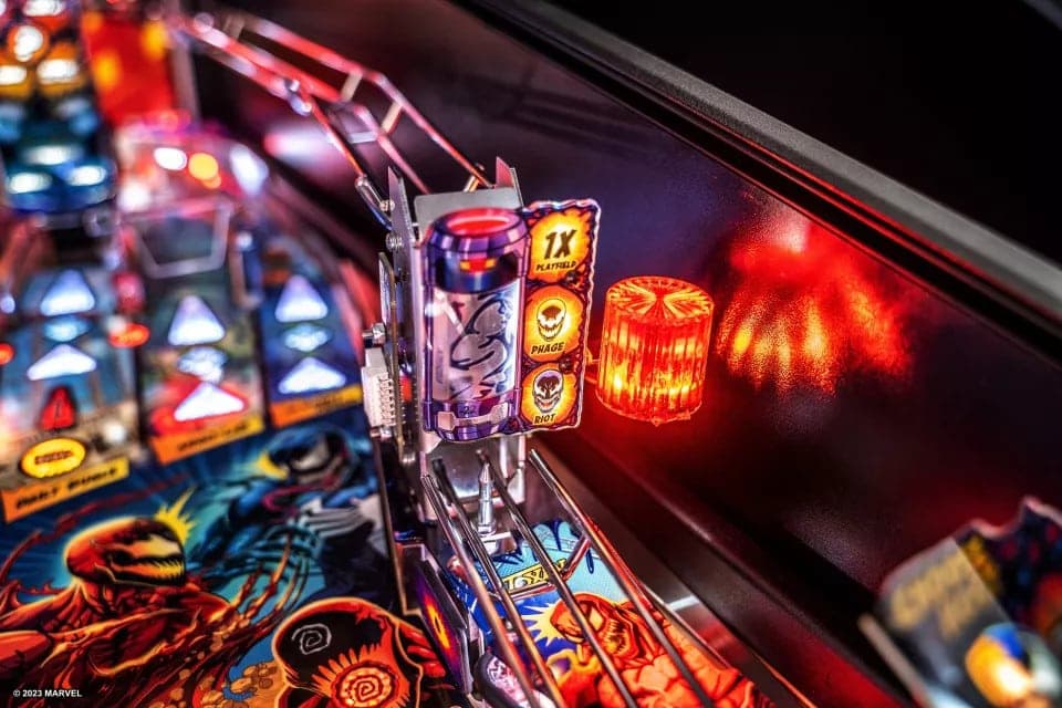 Colorful pinball machine with glowing lights and Marvel-themed artwork
