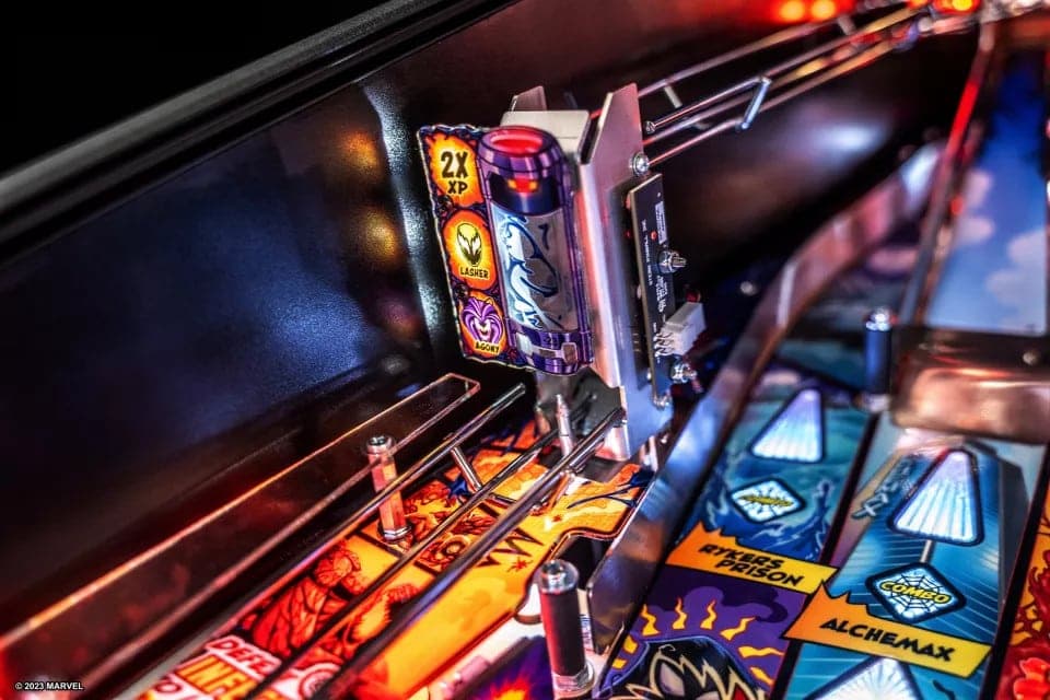 Colorful pinball machine with Marvel-themed graphics and glowing elements