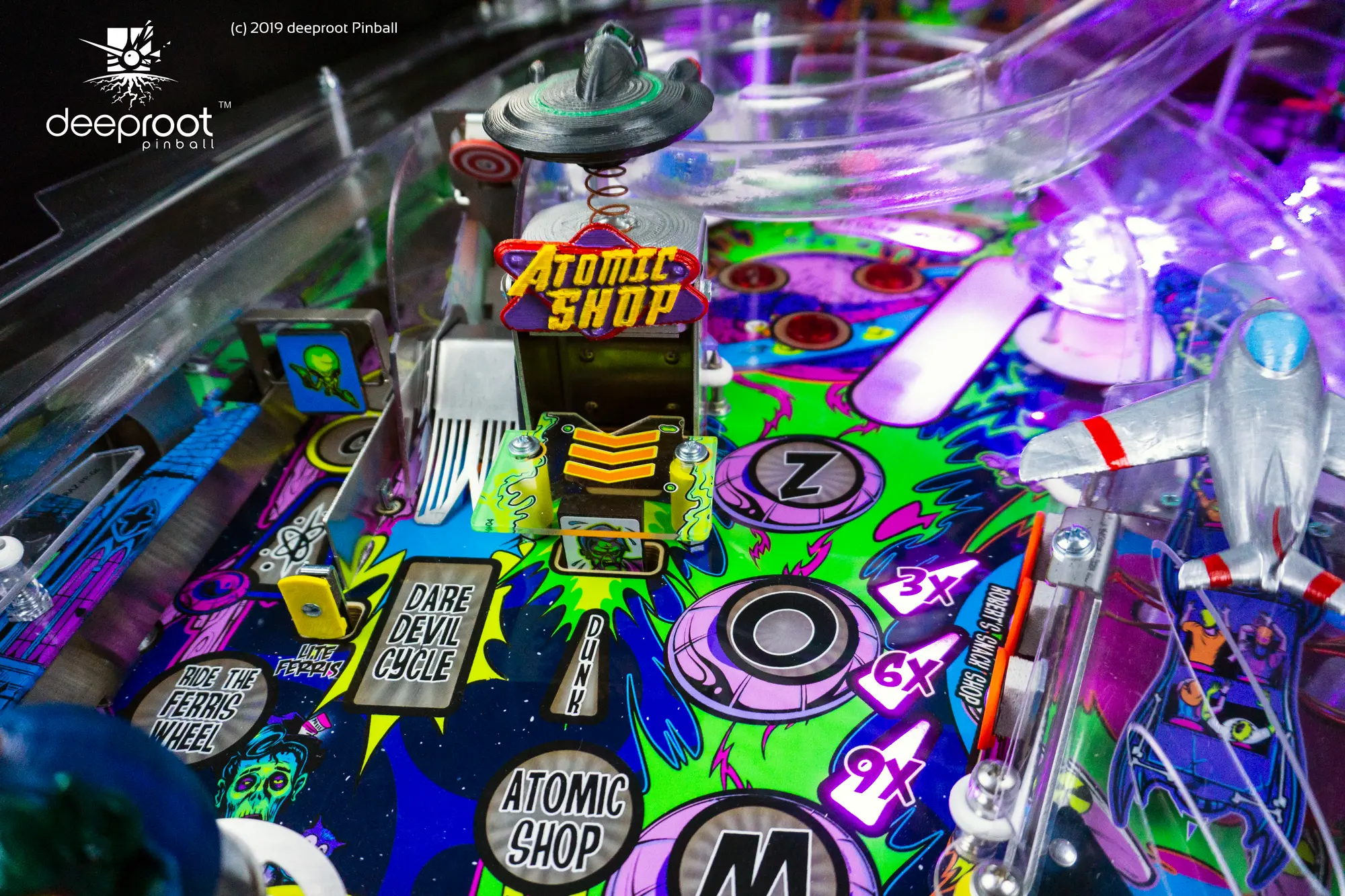 Colorful pinball machine with Atomic Shop sign and vibrant game elements