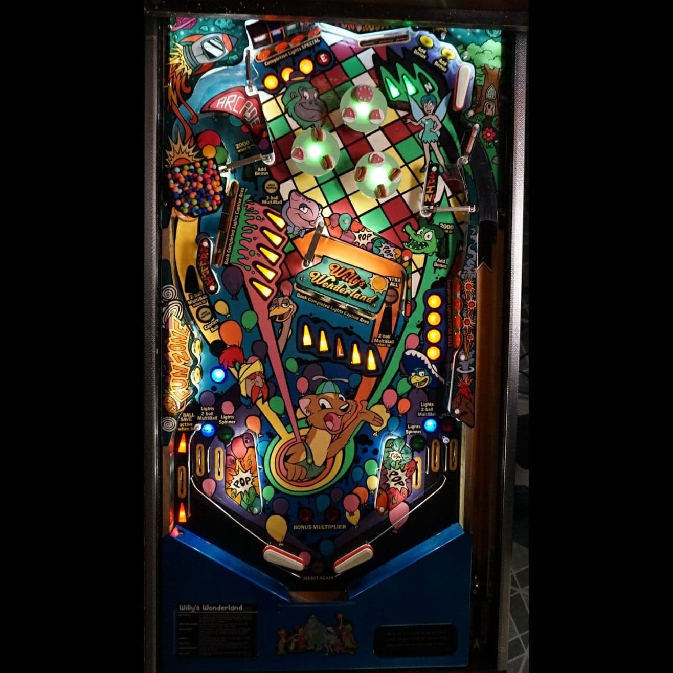 Colorful pinball machine playfield with Willy's Wonderland theme and cartoon characters