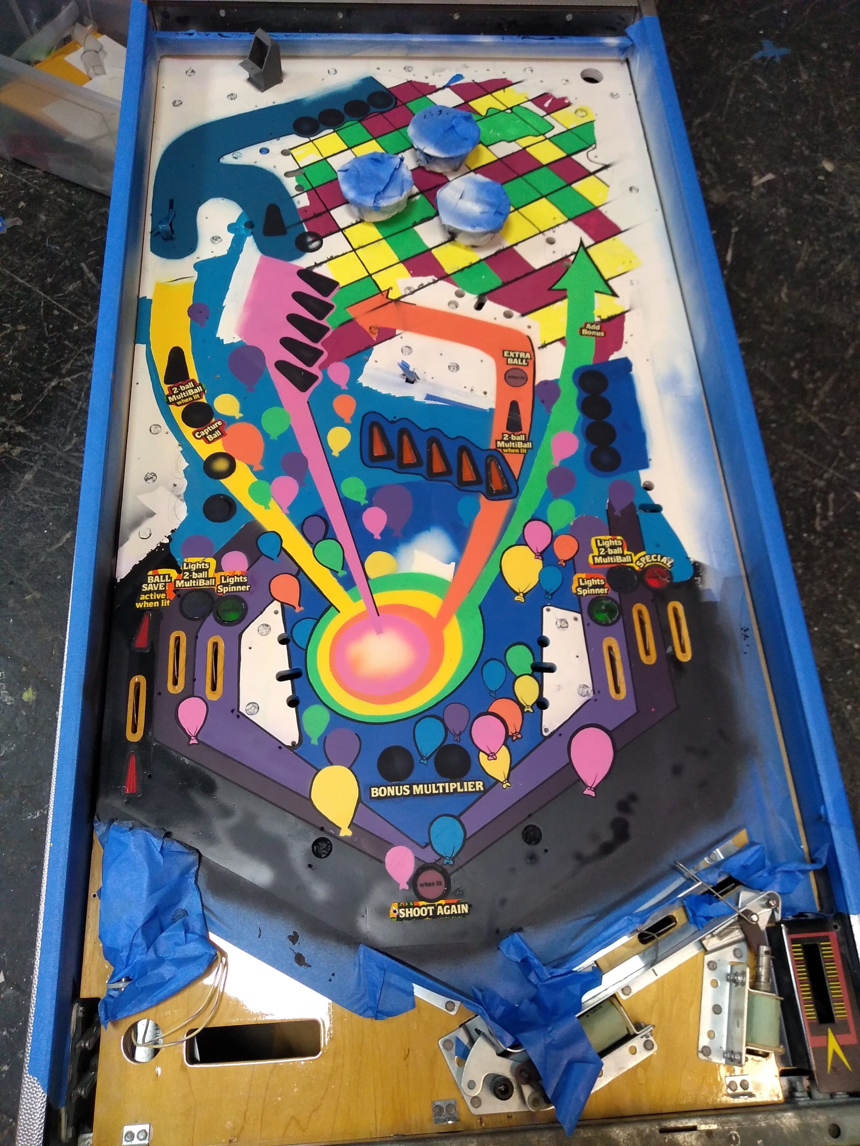 Colorful pinball machine playfield with balloons and bonus multiplier zones