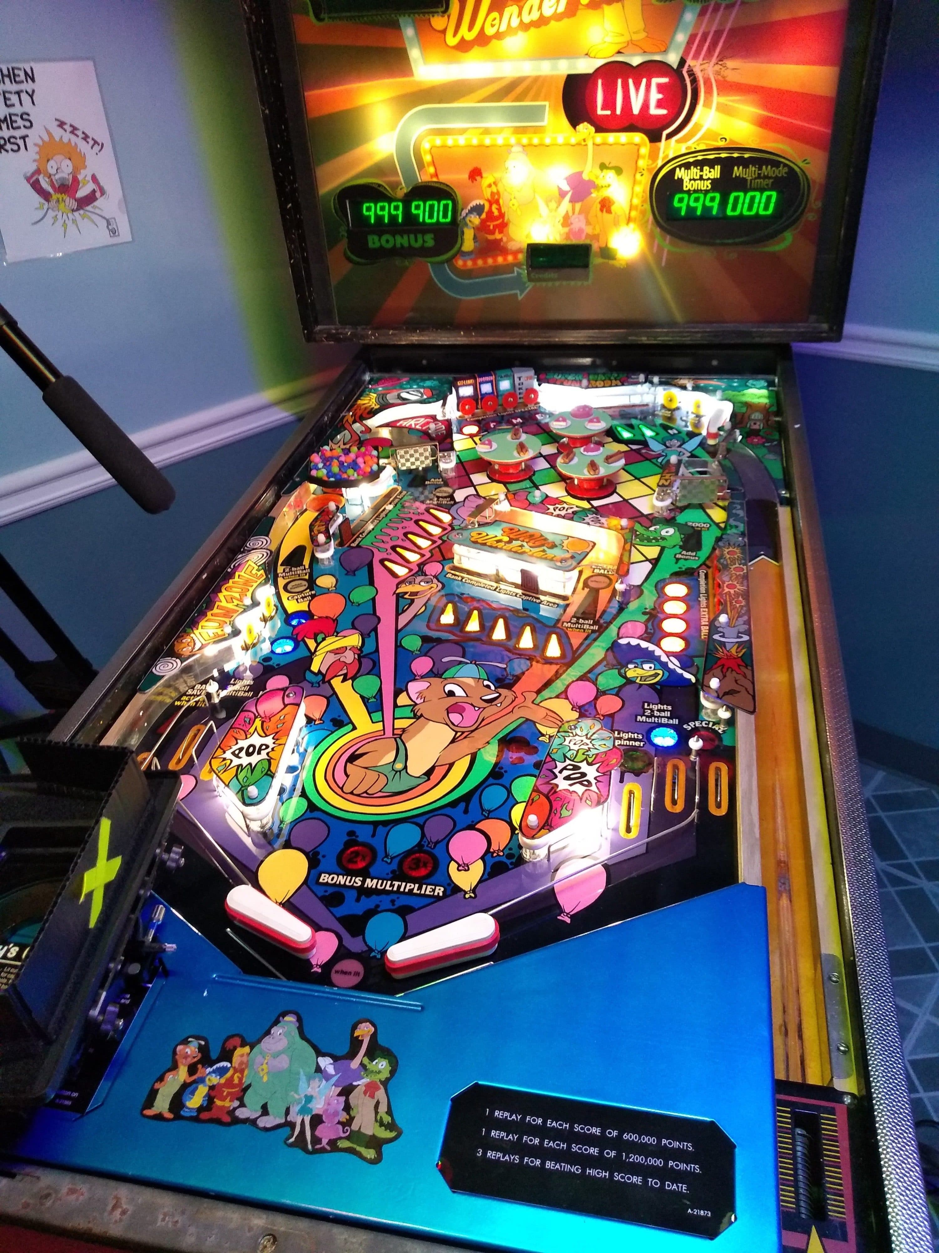 Colorful vintage pinball machine with animated characters and high scores