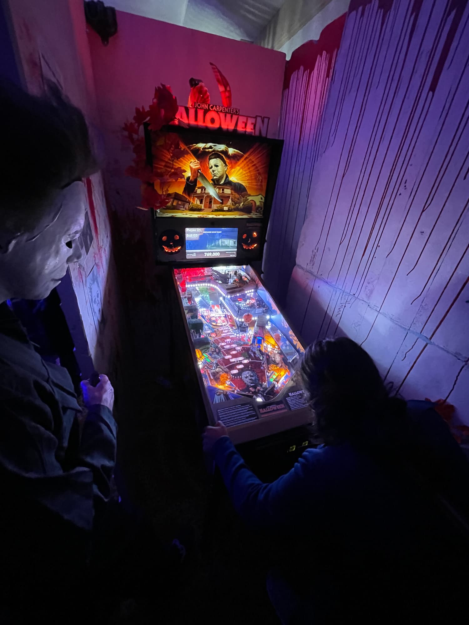 Halloween movie pinball machine with glowing backbox and playfield