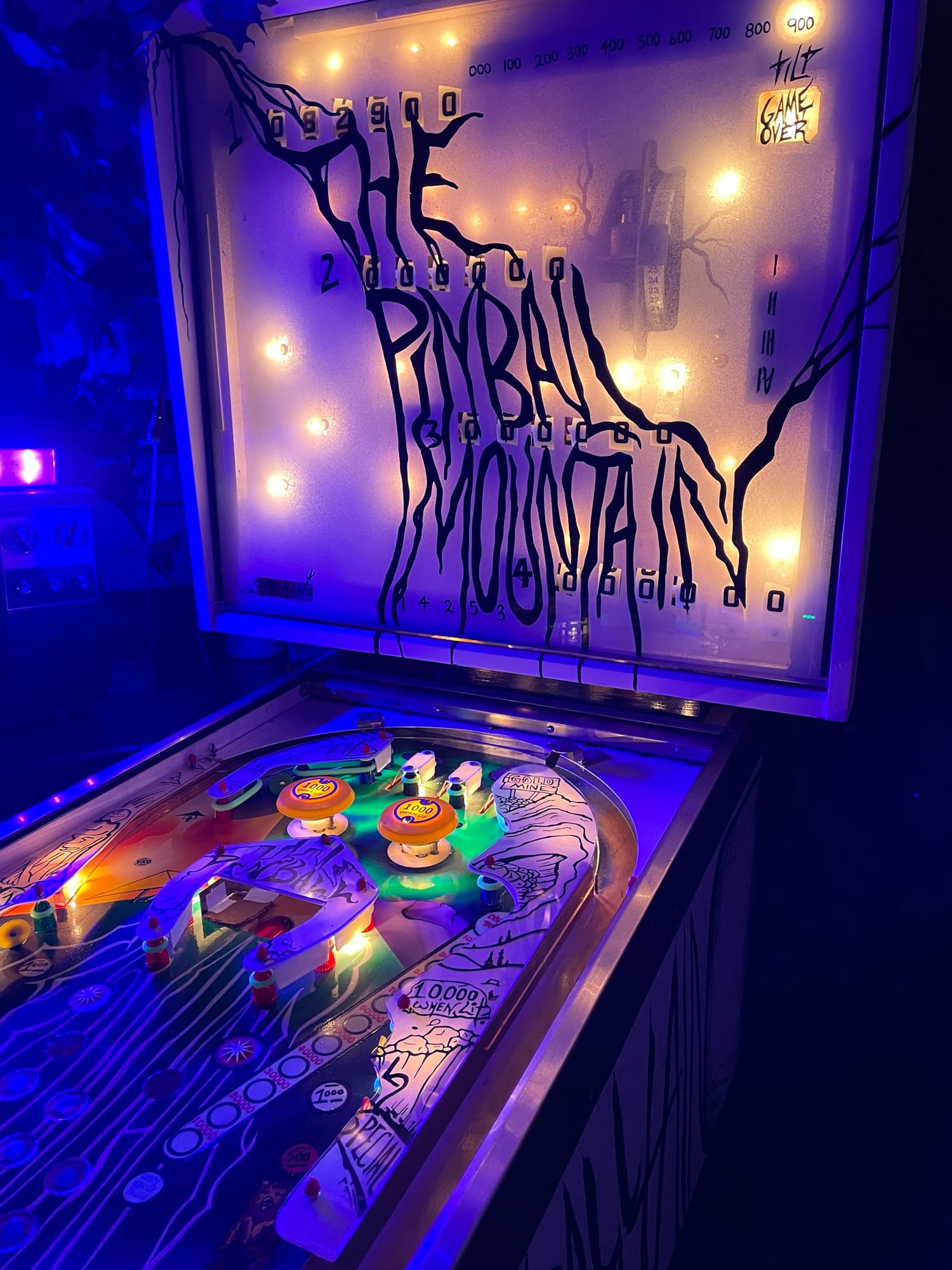 Vintage pinball machine with colorful lights and spooky Halloween-themed design
