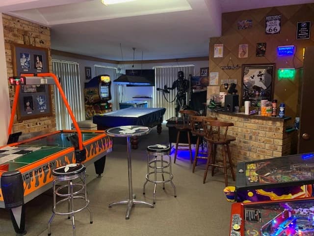 Game room with pinball machines, pool table, and vintage posters