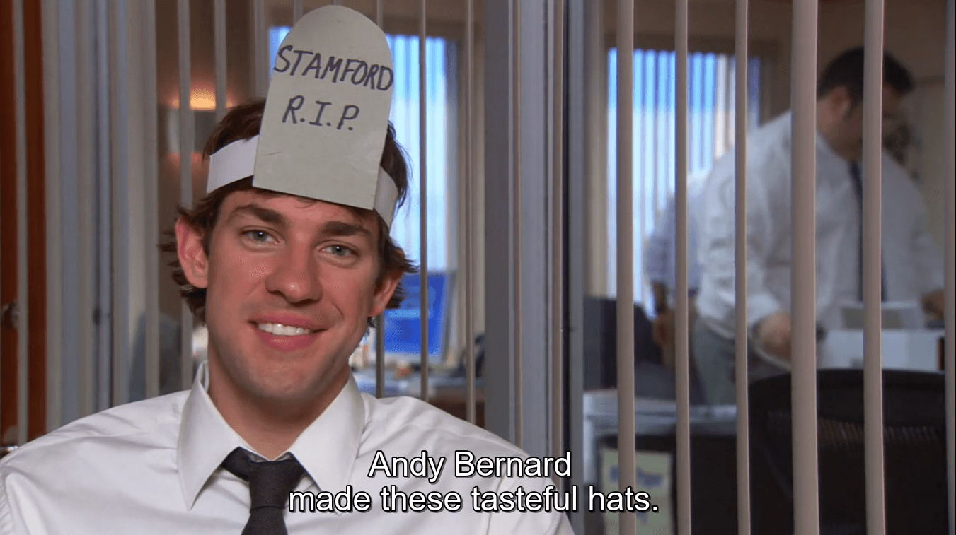 Smiling office worker wearing a "Stamford R.I.P." paper hat