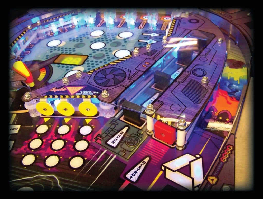 Colorful pinball machine playfield with glowing buttons and mechanical components
