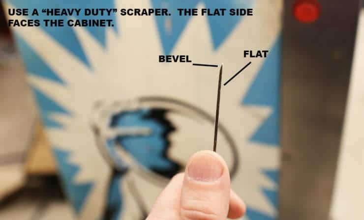 Hand holding a scraper with bevel and flat sides labeled