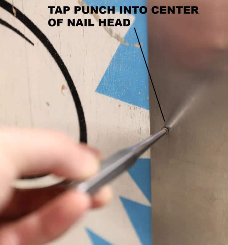 Tap punch positioned at center of nail head for precise metalworking