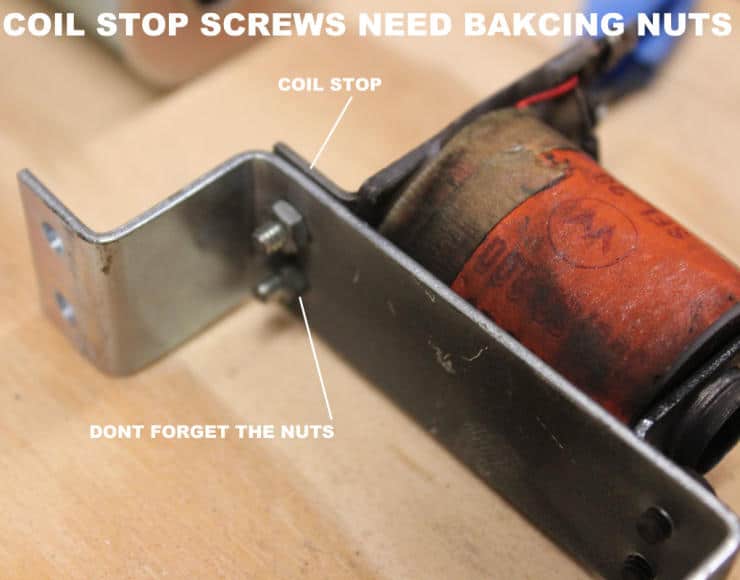 Red coil stop screw mounted on metal bracket with humorous annotation
