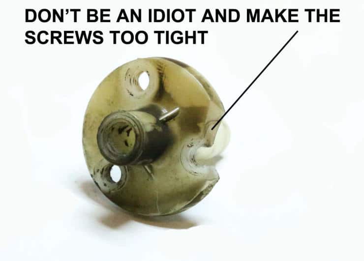 Cracked spherical object with warning about overtightening screws