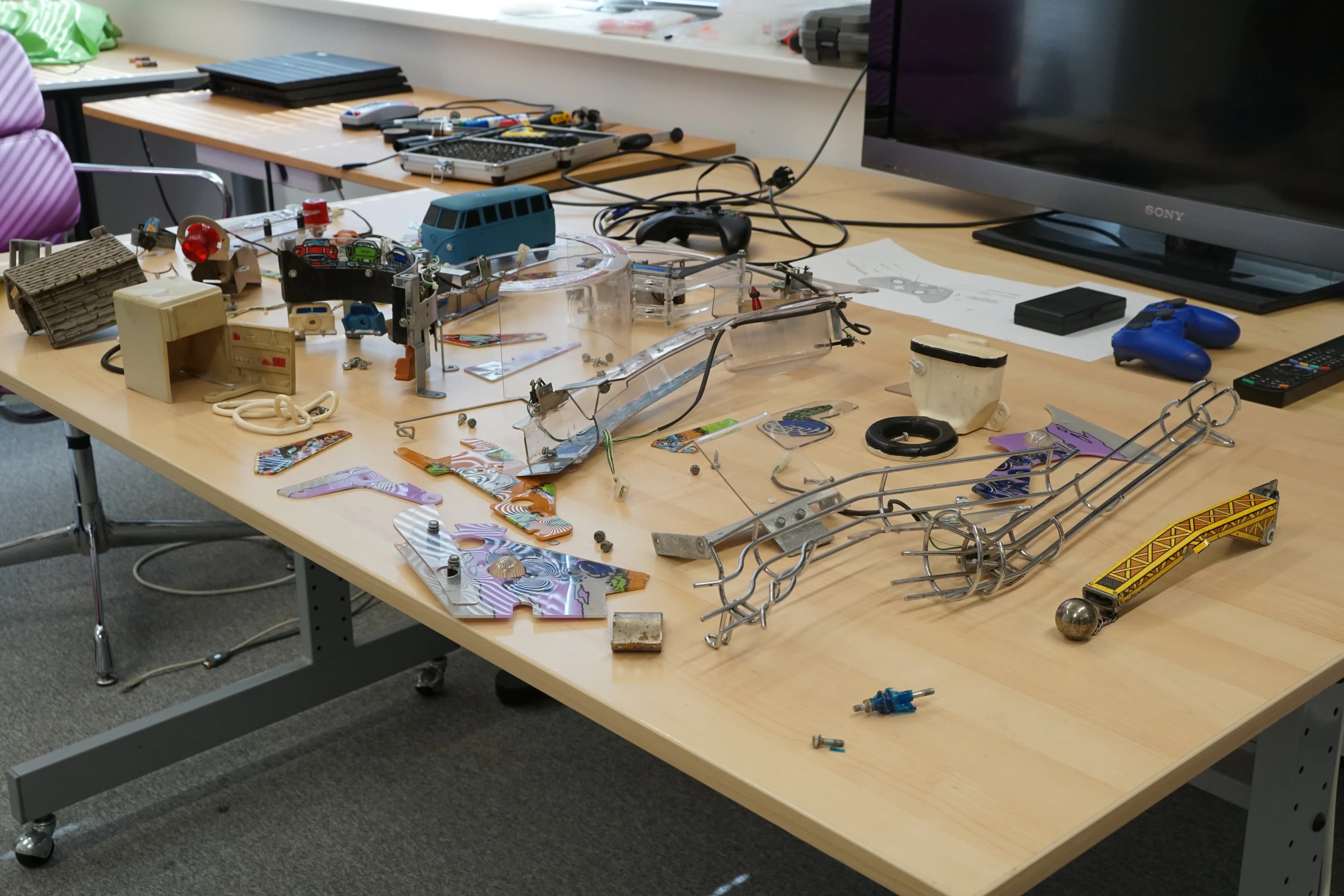 Workbench with robotics parts, toys, electronics, and mechanical components